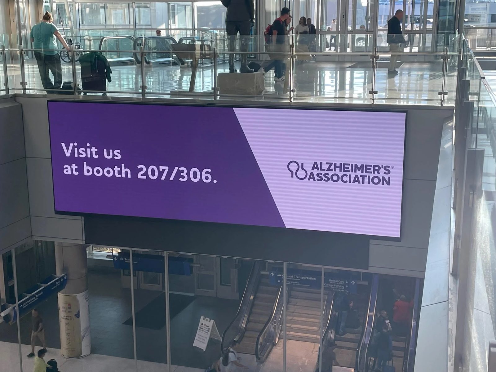 Escalator digital screen at the GSA 2022 Annual Scientific Meeting inviting attendees to the Alzheimer's Association booth